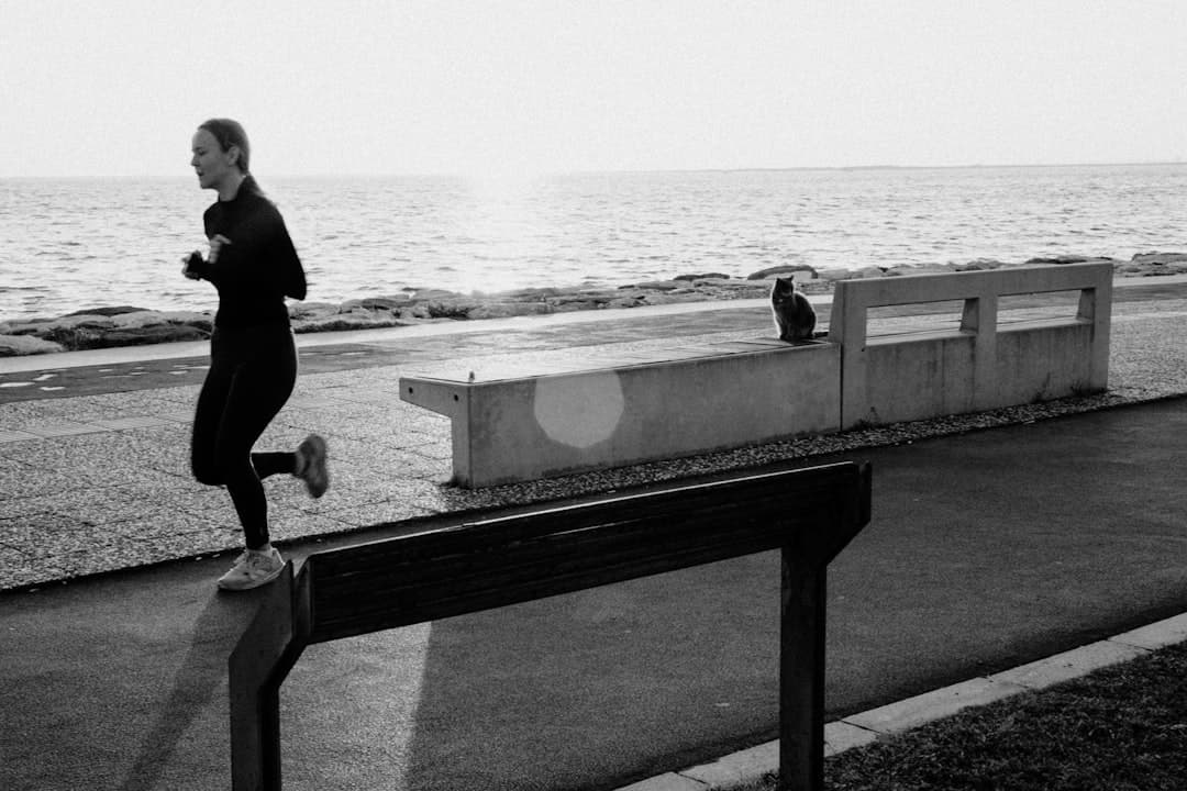 A woman running by the ocean at sunrise.
