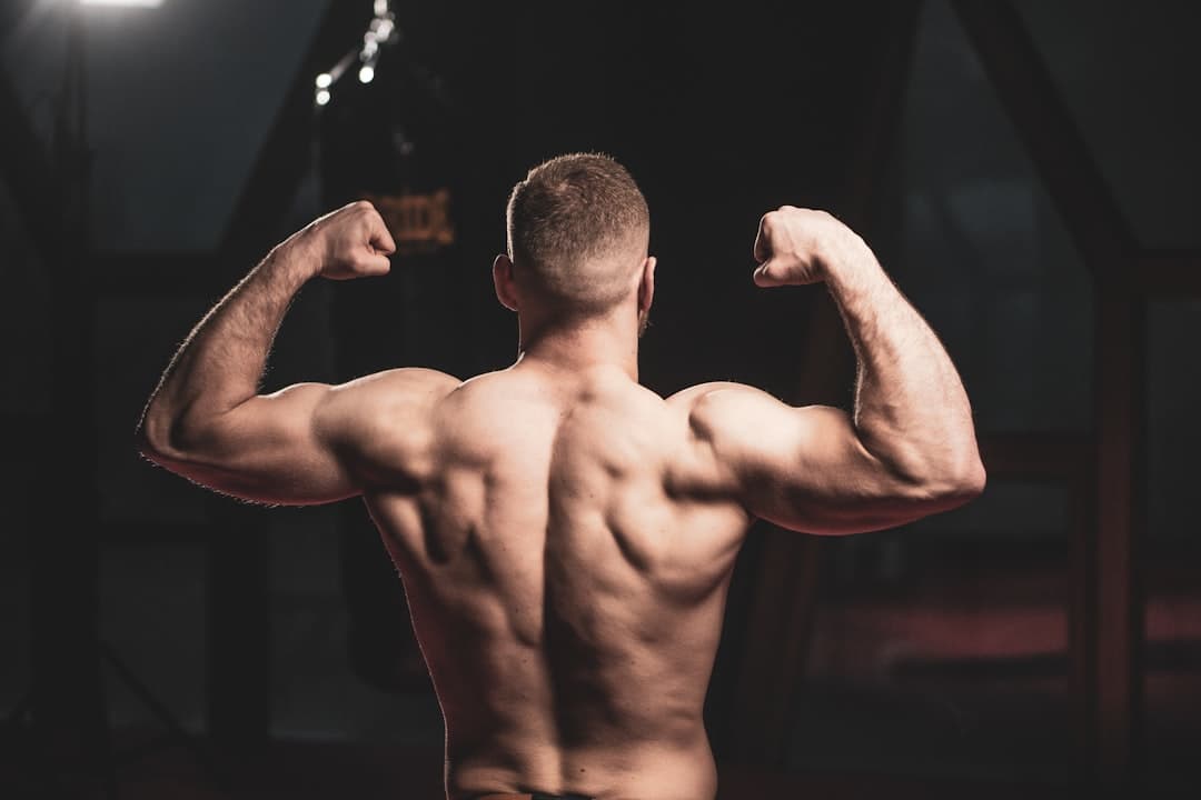 A man flexing his muscles in a gym.