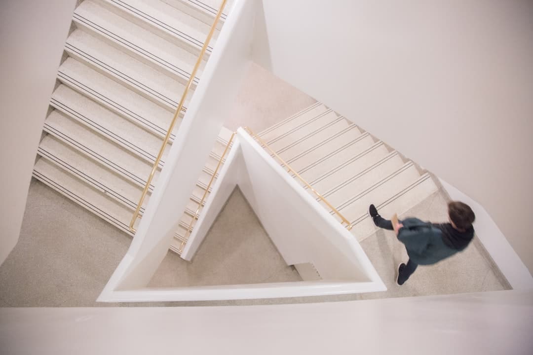 A person walking down a flight of white concrete stairs.