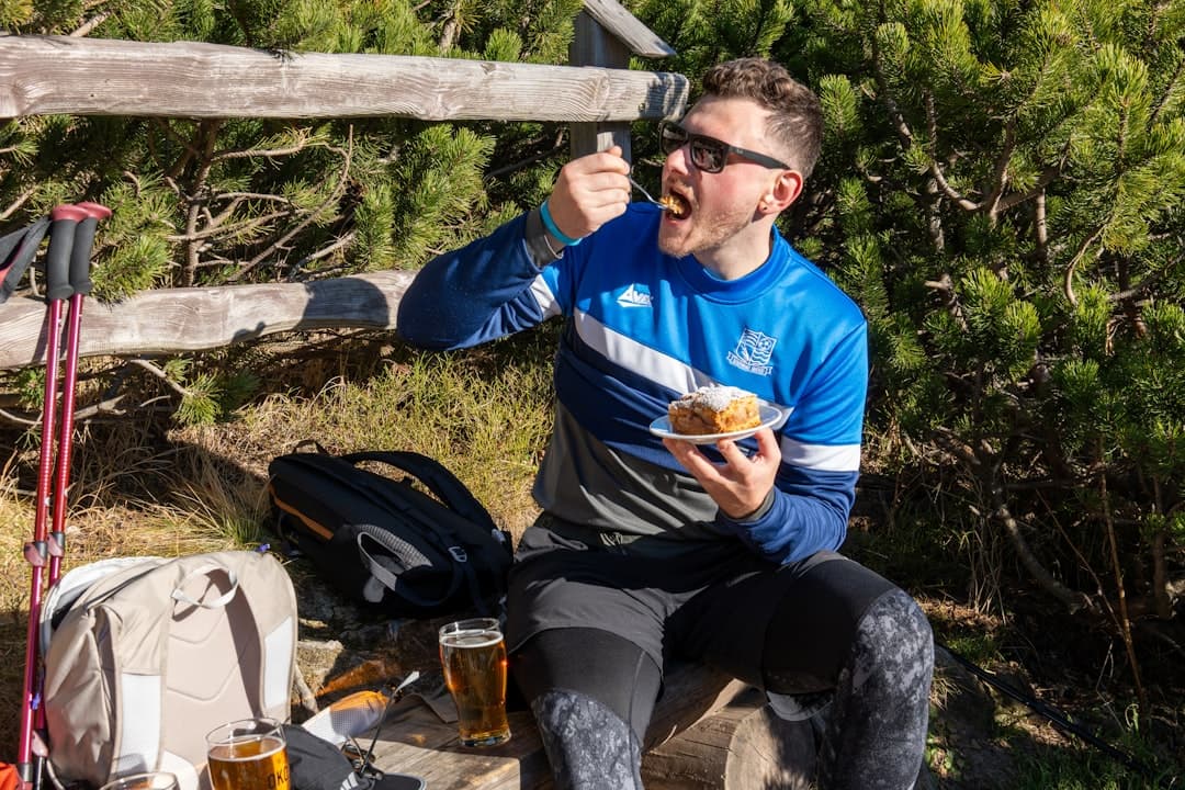 A man sitting on a rock eating food