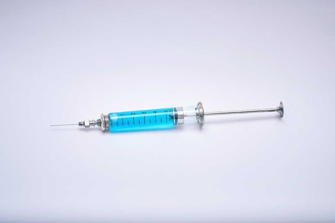 A blue and silver medical syringe on a white surface