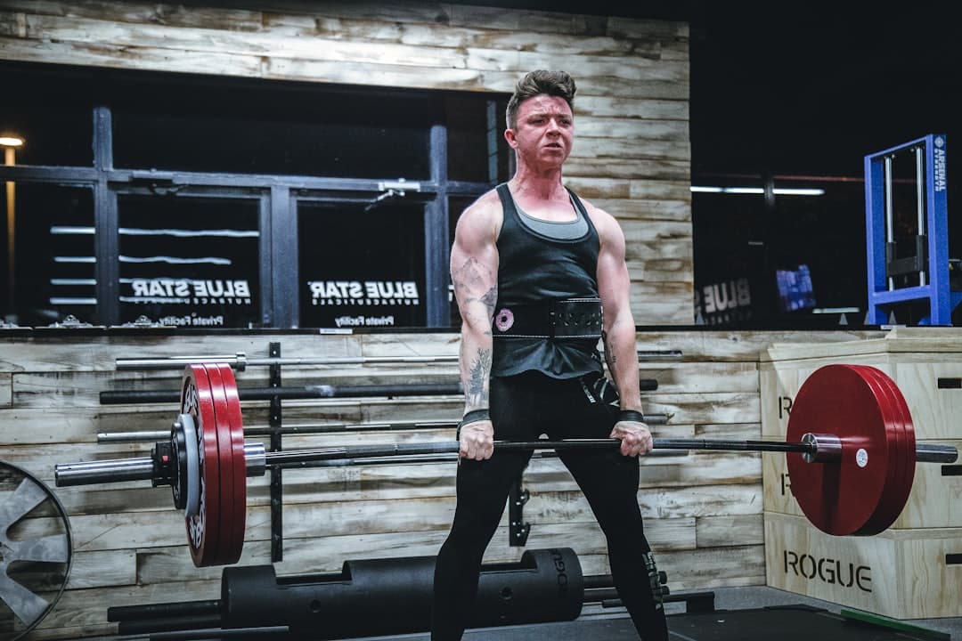 A man lifting a barbell during a heavy workout.