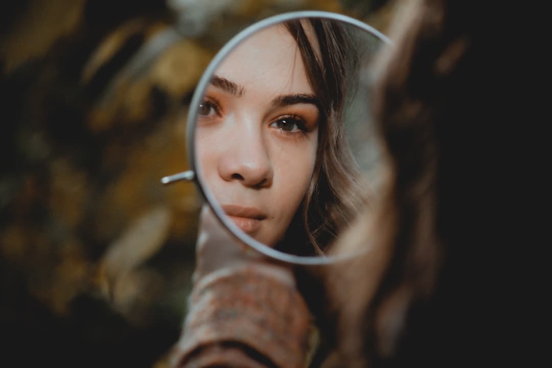 A person holding a magnifying glass examining skin